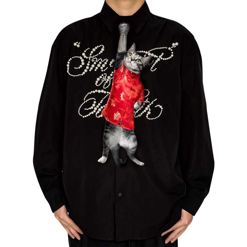 Novelty necktie featuring a realistic hanging grey cat wearing a festive red traditional-style top with gold patterns, a unique and eye-catching fashion accessory.