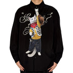"Novelty necktie featuring a white cat dressed as a cowboy, wearing a yellow plaid shirt, vest, jeans, bandana, and holding a hat