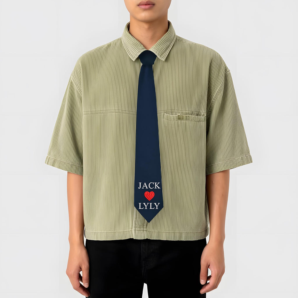 A dark blue custom necktie featuring the names 'JACK' and 'LYLY' embroidered with a red heart icon in the center, designed as a personalized gift