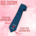 A dark blue custom necktie featuring the names 'JACK' and 'LYLY' embroidered with a red heart icon in the center, designed as a personalized gift