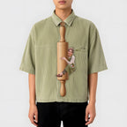 Novelty necktie featuring a graphic print of a person, dressed in an apron, hugging a wooden rolling pin. Text on the rolling pin reads 'Mrs. Smith