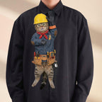 Novelty necktie featuring a tabby cat dressed as an electrician in a denim shirt, red bandana, and yellow hard hat, complete with a tool belt featuring various electrical tools and a multimeter