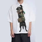 Novelty necktie featuring a black Labrador retriever dressed in a hunting vest, carrying a mallard duck in its mouth, appearing to hang from the wearer's collar