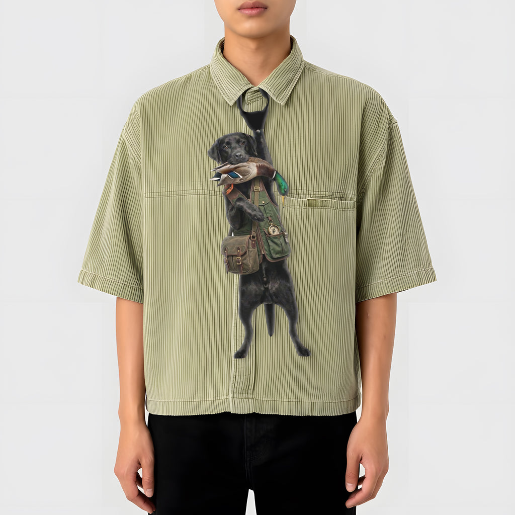 Novelty necktie featuring a black Labrador retriever dressed in a hunting vest, carrying a mallard duck in its mouth, appearing to hang from the wearer's collar