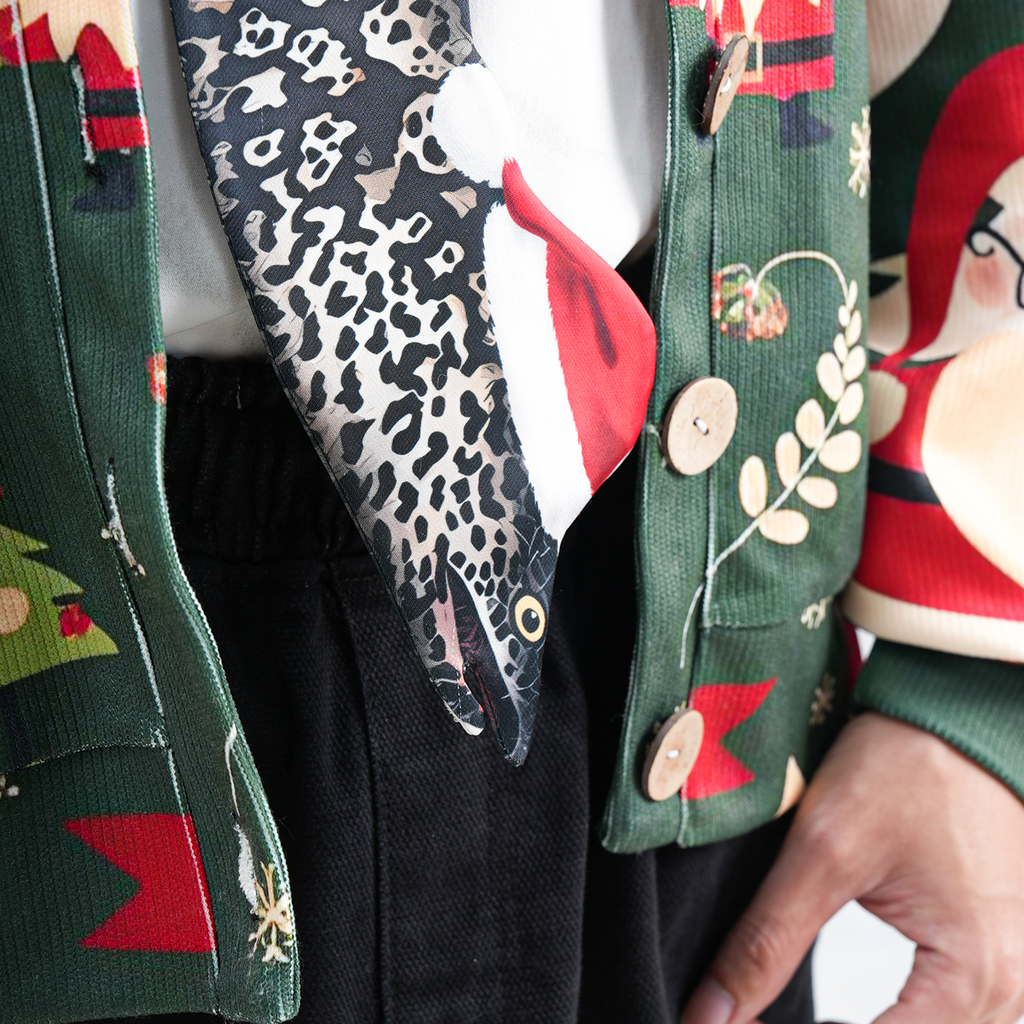Eel-shaped novelty tie with a unique leopard print pattern and Santa hat, fun animal-themed festive accessory.