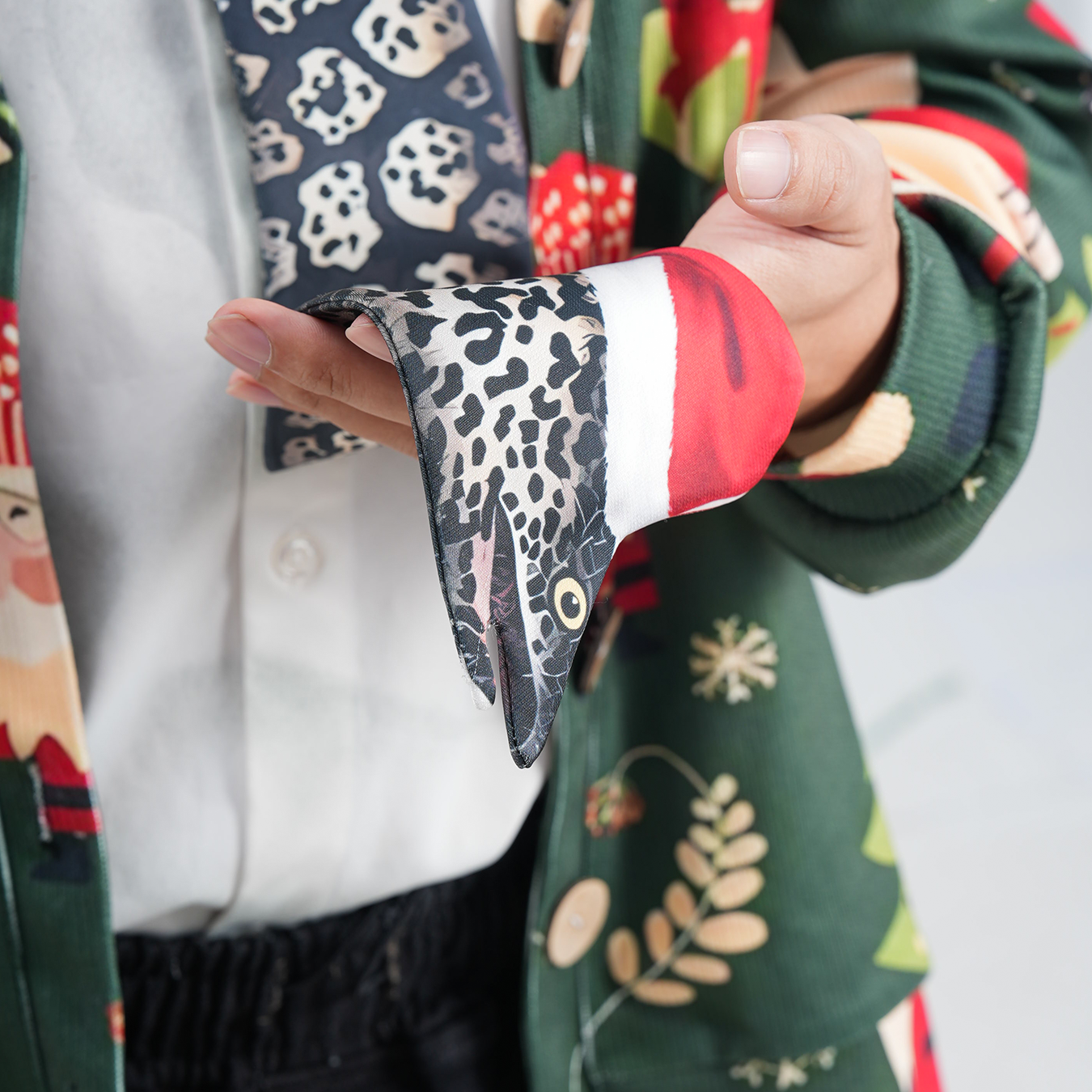 Eel-shaped novelty tie with a unique leopard print pattern and Santa hat, fun animal-themed festive accessory.