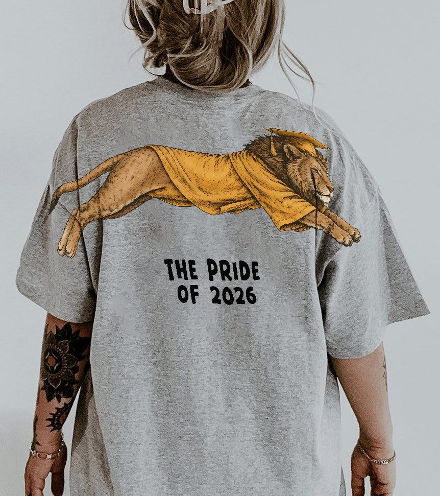 Lion The Pride of 2026 graduation graphic tee by Dripvity, unisex oversized white t-shirt with leaping lion in graduation cap and gown