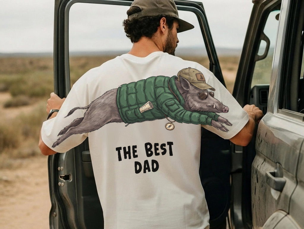 The Best Dad wild boar graphic tee funny fathers day by Dripvity, unisex oversized white t-shirt with adventurous boar wearing jacket and cap design