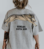 Wolf Howling Outta Here graduation graphic tee by Dripvity, unisex oversized white t-shirt with leaping wolf in graduation cap and diploma