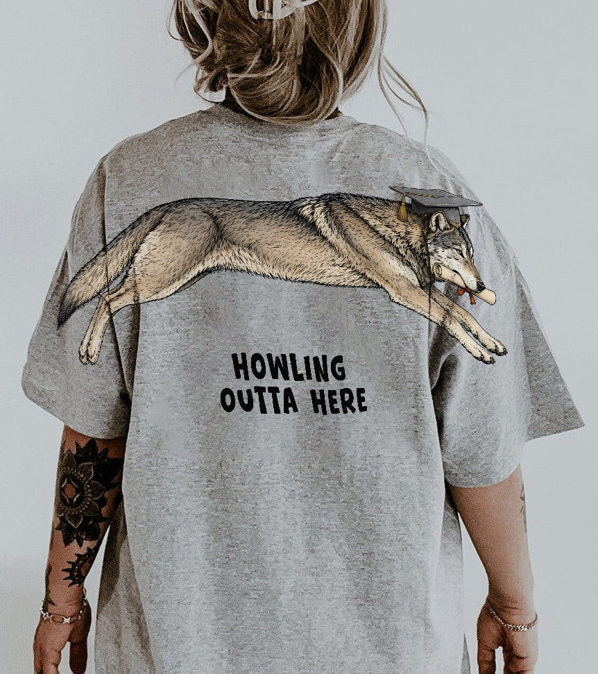 Wolf Howling Outta Here graduation graphic tee by Dripvity, unisex oversized white t-shirt with leaping wolf in graduation cap and diploma