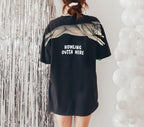 Wolf Howling Outta Here graduation graphic tee by Dripvity, unisex oversized white t-shirt with leaping wolf in graduation cap and diploma