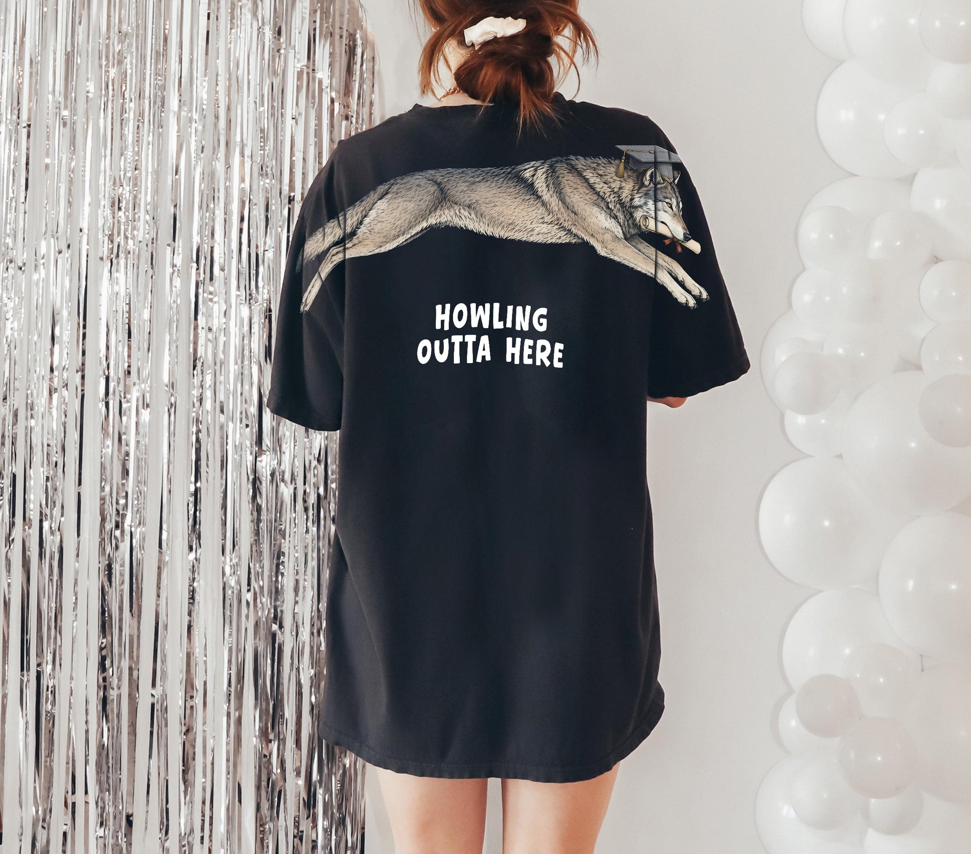 Wolf Howling Outta Here graduation graphic tee by Dripvity, unisex oversized white t-shirt with leaping wolf in graduation cap and diploma