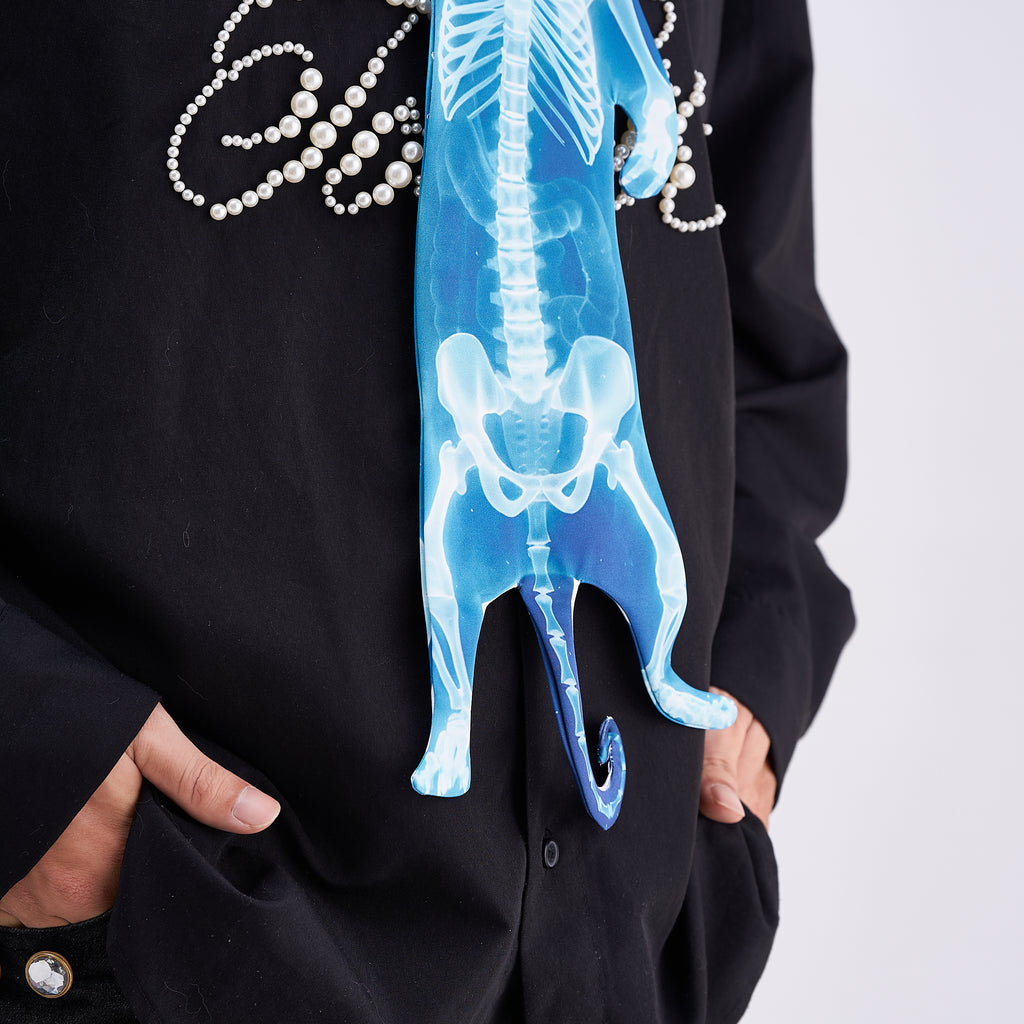 Unique novelty necktie featuring a blue X-ray skeleton design of a cat, an edgy and artistic fashion accessory.