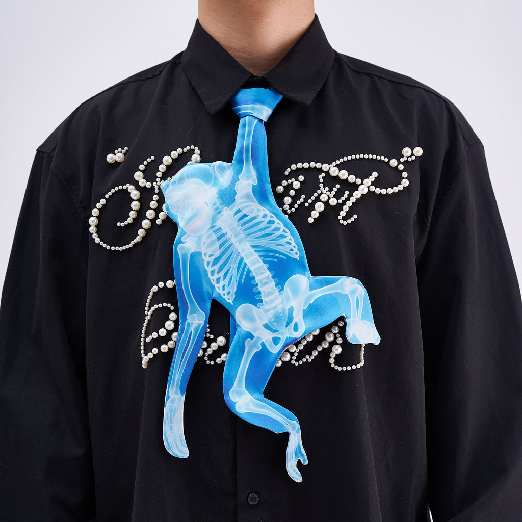 Unique novelty tie featuring a blue X-ray skeleton design of a monkey, a bold and edgy fashion accessory for creative outfits.