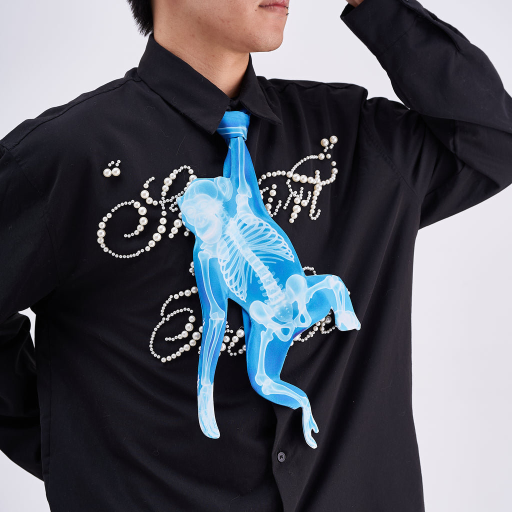 Unique novelty tie featuring a blue X-ray skeleton design of a monkey, a bold and edgy fashion accessory for creative outfits.